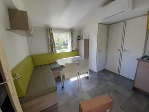 a kitchen with a table and chairs in a room at Mobil-home Moon River in Thiviers