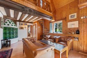 a living room with leather furniture and wooden walls at Erlaufsee Estate by Landluft in Mitterbach