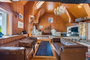 a living room with leather furniture and a chandelier at Erlaufsee Estate by Landluft in Mitterbach