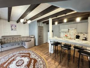 a kitchen and living room with a table and chairs at Котедж у Софійки in Synevyrsʼka Polyana