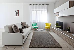 a white living room with a couch and a tv at Aranci 99 House in Sorrento