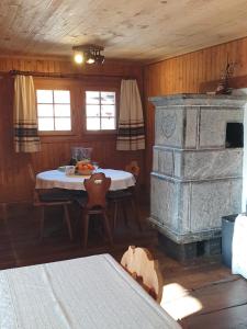 a living room with a table and a stone fireplace at Magnifique chalet familial in Evolène