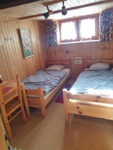 a room with two beds and a chair in it at Magnifique chalet familial in Evolène