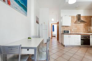 a kitchen with white cabinets and a table and chairs at Apartamento Luminoso Lagos Cotillo in El Cotillo