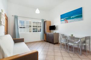 a living room with a couch and a table and chairs at Apartamento Luminoso Lagos Cotillo in El Cotillo