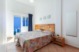 a bedroom with a bed and a door to a balcony at Apartamento Luminoso Lagos Cotillo in El Cotillo