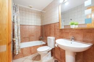 a bathroom with a toilet and a sink and a tub at Apartamento Luminoso Lagos Cotillo in El Cotillo +15 photos