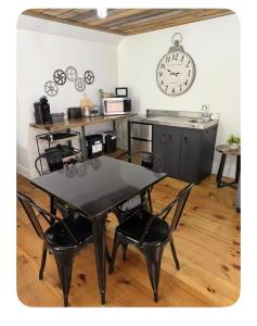 a table and chairs in a kitchen with a clock on the wall at Sleep at Simplicity in Massena +4 photos
