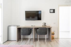 a table with two chairs and a television on a wall at Le Monde 2 in Borsh