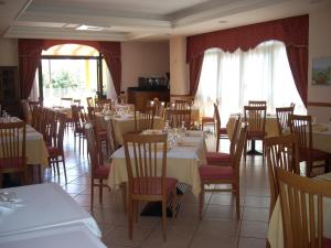 a dining room with tables and chairs and a room with white tables at Hotel Margherita in San Giovanni Rotondo