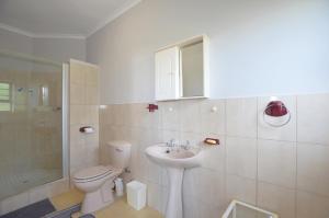 a white bathroom with a toilet and a sink at Cosy House in Yzerfontein +17 photos
