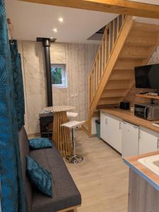 a living room with a couch and a staircase at Au Bois Dormant B&B in Tillé