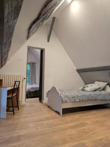a bedroom with a bed and a table and a mirror at Au Bois Dormant B&B in Tillé