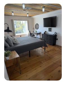 a bedroom with a bed and a desk and a television at Sleep at Simplicity in Massena