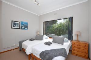 a bedroom with two beds and a large window at Cosy House in Yzerfontein