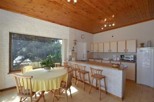 a kitchen with a table and some chairs and a counter at Cosy House in Yzerfontein