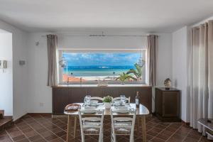 a dining room with a table and a view of the ocean at Villa Thalissa by Perle di Puglia in Taranto