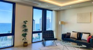 a living room with a couch and large windows at Stay in WAVE in Ch'ŏngsap'o