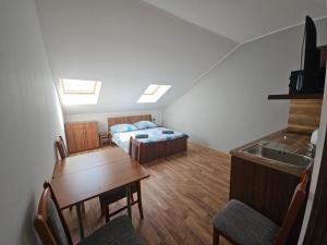 a room with a bed and a table and a kitchen at Penzion u Vinice in Sedlec