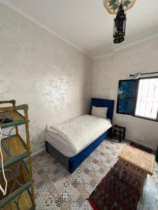 a small bedroom with a bed and a window at Hostel Tanger Medina in Tangier