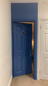 a blue door in a room with a white wall at Blue Room in Ifield