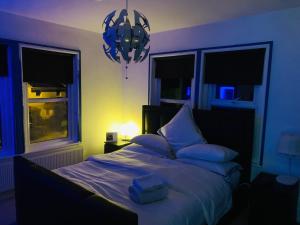a bedroom with a large bed with a blue light at Blue Room in Ifield