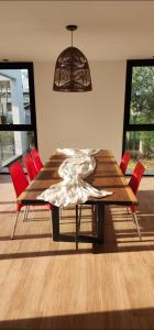 a dining room table with red chairs and a lamp at Casa Quinta El Rodeo in La Plata