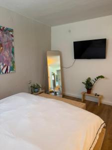 a bedroom with a white bed and a mirror at צימרים בצפון - אדם אדמה in Sheʼar Yashuv