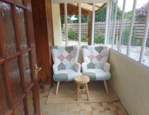 two chairs and a table on a porch at Keriven Cottage in Caurel +44 photos