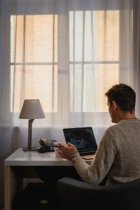 a woman sitting at a desk with a laptop computer at Stay inn Hotel Gdańsk in Gdańsk