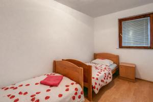 a bedroom with two beds and a window at MAAR Kovačić Apartmani in Zaton