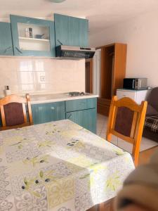 a kitchen with a table with a table cloth on it at MAAR Kovačić Apartmani in Zaton