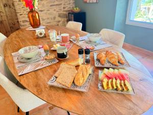 a wooden table with plates of food on it at La-Vialette Chambres d Hôtes in Mont-Roc