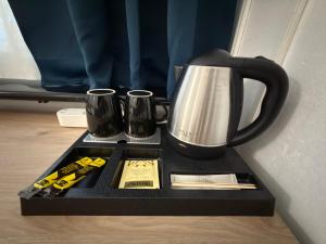 a tray with a coffee pot and cups on it at Hotel San Carlo in Lugano