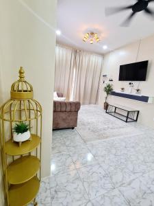a living room with a couch and a tv at Homestay THE INDRA in Kuantan