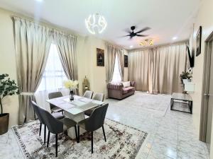a living room with a table and chairs and a couch at Homestay THE INDRA in Kuantan