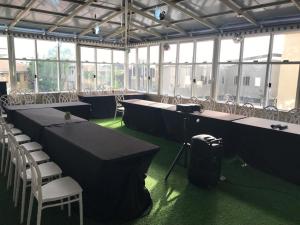 a large room with tables and chairs and windows at ADJ Royalty Hotel & Suites in Benin City +35 photos