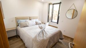 a bedroom with a bed with a mirror on the wall at As Casas do Penedo da Moura in Arcos de Valdevez