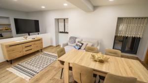 a living room with a dining table and a television at As Casas do Penedo da Moura in Arcos de Valdevez