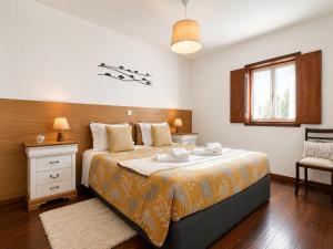 a bedroom with a large bed and a window at Refúgio do Vidoeiro in Geres