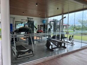 a gym with several tread machines in a glass wall at Vistas de Gravatá in Gravatal