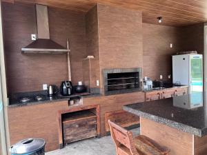 a kitchen with a counter and a stove and a refrigerator at Vistas de Gravatá in Gravatal +13 photos