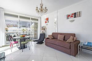 a living room with a couch and a table at Mer Vue Sublime in Canet-en-Roussillon