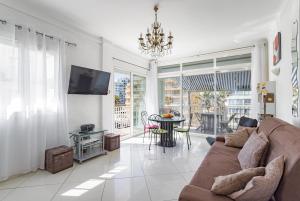 a living room with a couch and a table at Mer Vue Sublime in Canet-en-Roussillon