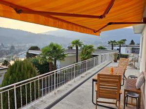 a patio with a table and chairs on a balcony at Villa Caslano in Caslano