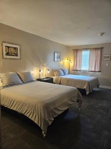 a hotel room with two beds and a window at Mountain Creek Tavern in Mount Holly Springs