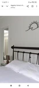 a bedroom with a white bed with a black frame at aggelos home in Kato Alepochori