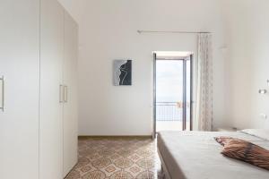 a bedroom with a bed and a door to a balcony at La casa del sole in Conca dei Marini