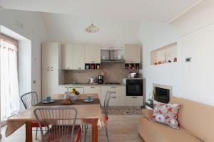 a kitchen and living room with a table and a couch at La casa del sole in Conca dei Marini