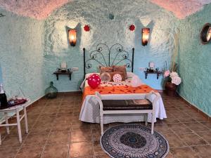 a bedroom with a bed with an orange bedspread at Cueva La Panadera - CuevasCazorla in Hinojares